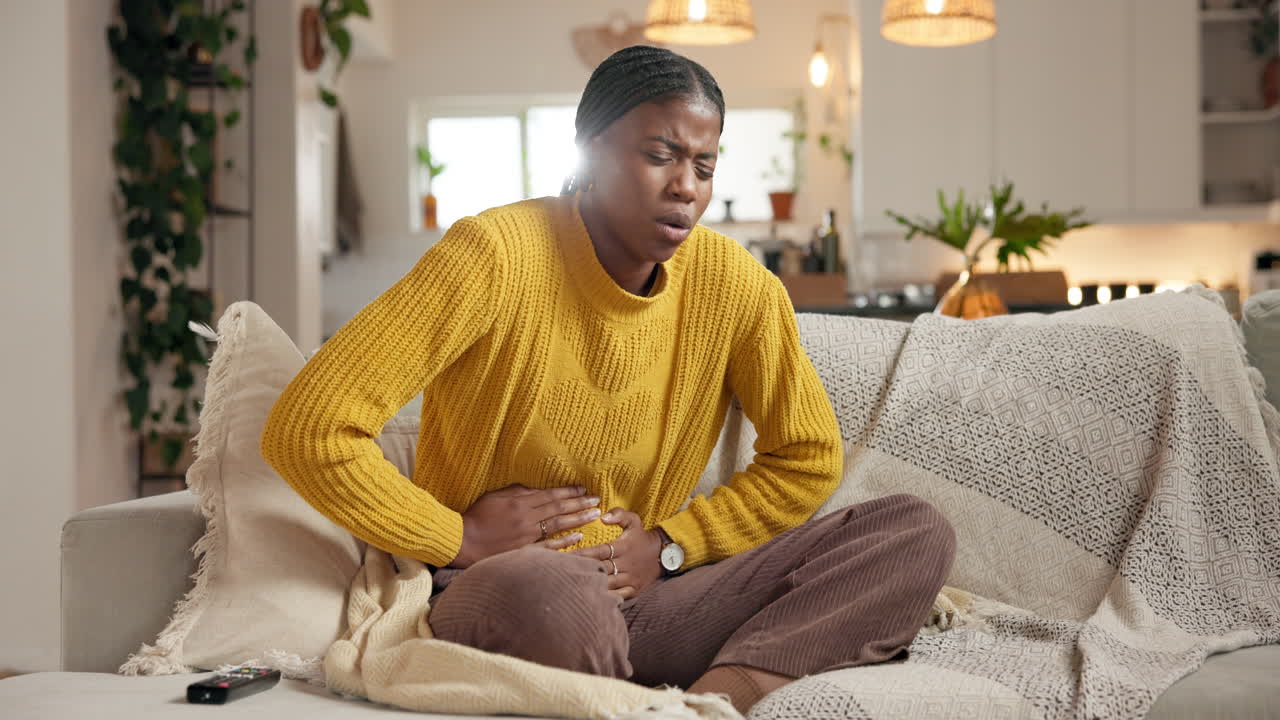 Woman experiencing abdominal pain at home