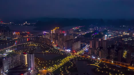 bird's light city of multi-level junction road lands with moving cars traffic of modern highway with overpass bridge at countryside
