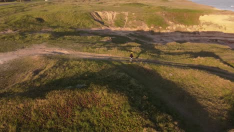 Mujer-Aislada-Caminando-Por-El-Sendero-Frente-Al-Mar-Al-Atardecer,-Mar-Del-Plata-En-Argentina