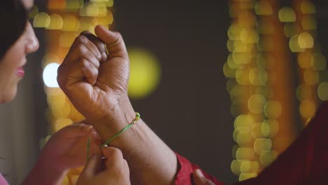 sister ties rakhi on brother during raksha bandhan with a hug, slow motion