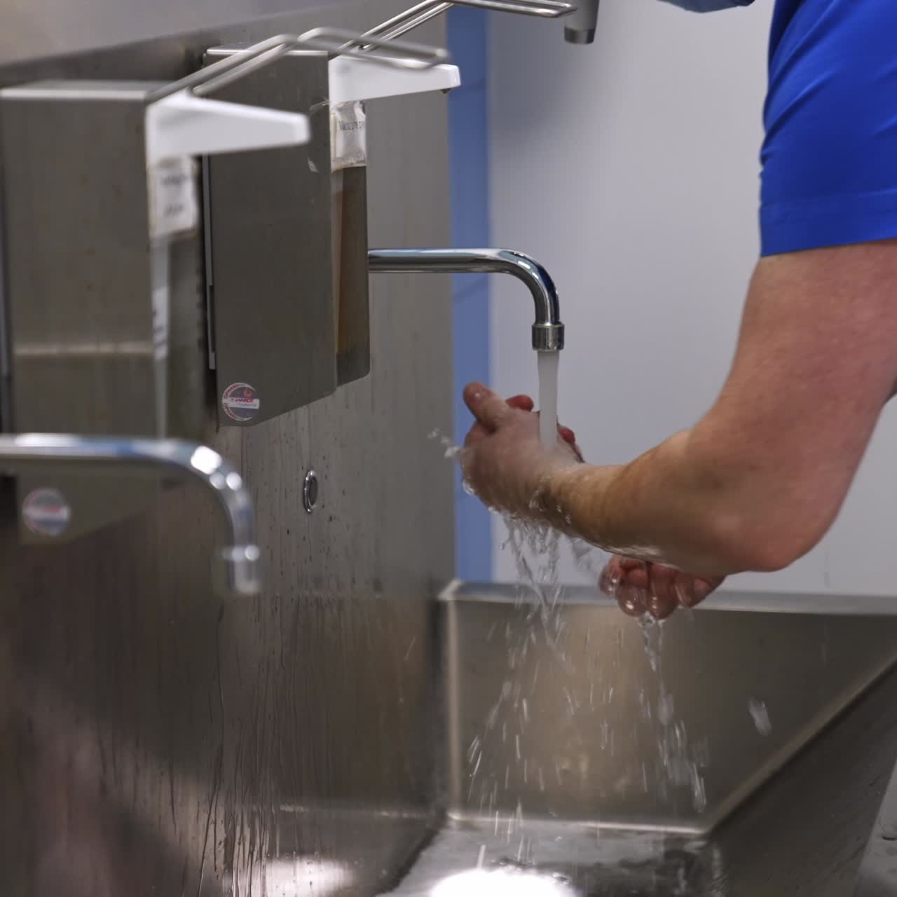 Surgeon washing hands carefully preparing for operation. Unrecognized doctor getting ready for surgery in the preoperational room
