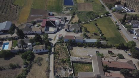 Toma-Aérea-Con-Inclinación-Hacia-Arriba-En-Un-Pequeño-Pueblo-Del-Sur-De-España-Con-Campos-De-Olivos