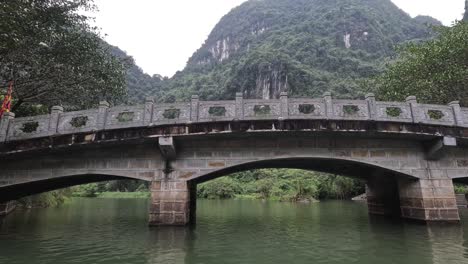 passing under a stone bridge in ninh binh