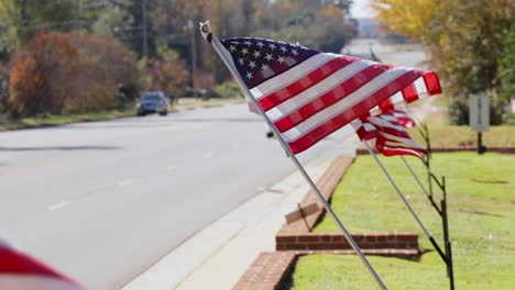 banderas americanas alineadas ondeando en cámara lenta cerca de la carretera