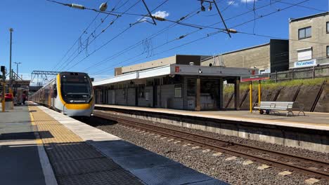 train arriving at platform 3 of bowen hills station, inner city travel on a sunny day, translink queensland railway public transportation, brisbane city, australia