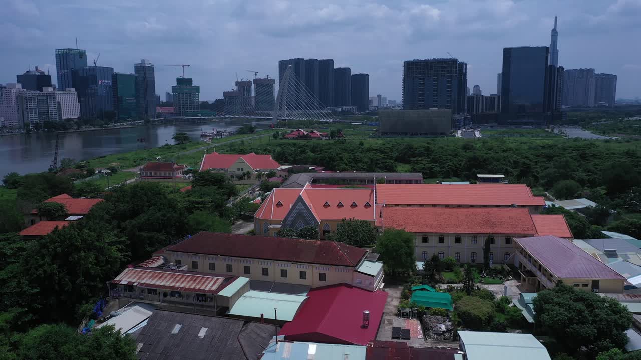 Thủ Thi&ecirc;m Parish Church and the Lovers of the Holy Cross Convent are the oldest French Colonial buildings in Ho Chi Minh City, Vietnam Aerial view flying in over convent revealing the city skyline