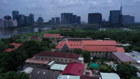 thủ thiêm parish church and the lovers of the holy cross convent are the oldest french colonial buildings in ho chi minh city, vietnam aerial view flying in over convent revealing the city skyline