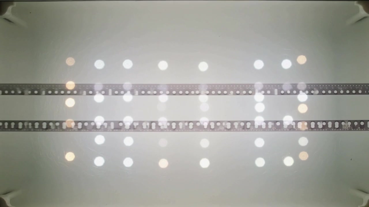Shifting light causing tray reveal on lightbox showing two 35mm strips with bokeh grid for review