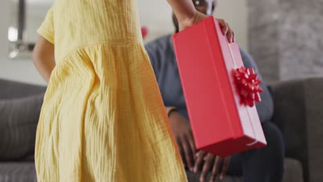African-american-daughter-giving-present-to-surprised-father
