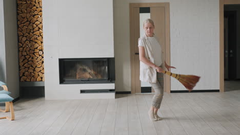 woman cleaning the living room with broom