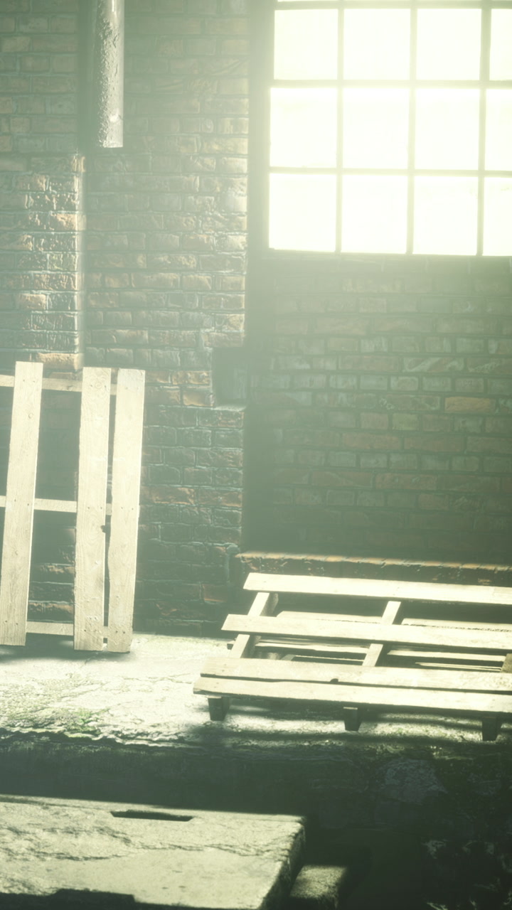 Wooden pallets near a dark wall and a window showing light in a warehouse