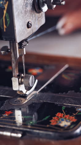 woman at sewing machine. creative dressmaker woman working with threads on sewing machine vertical video