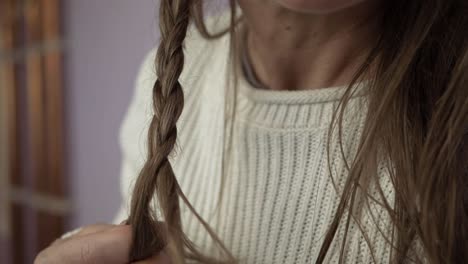 Woman-plaiting-long-hair-close-up-shot