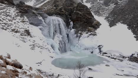 ice covered waterfall, helgufoss, in early spring