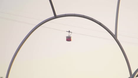 red cable car passes over barcelona sailboat bay view at sunset in january