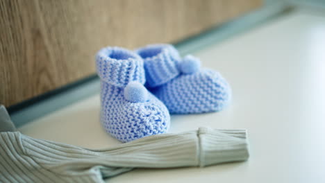blue knitted boots and clothes prepared for the newborn baby. little boy expectation. close up.