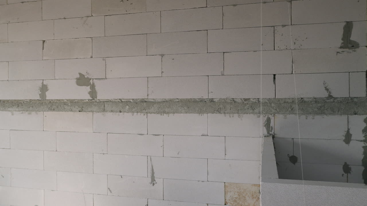 Panning from the right side to the left side of the frame showing hollow blocks layeres in a building being constructed in a province in the outskirts of Bangkok, Thailand