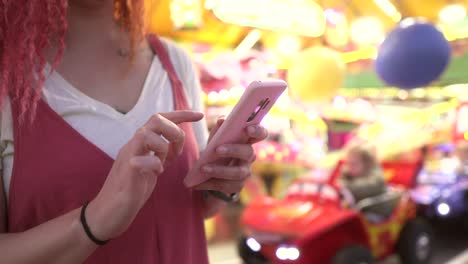 detail of woman hands using smartphone at the fair