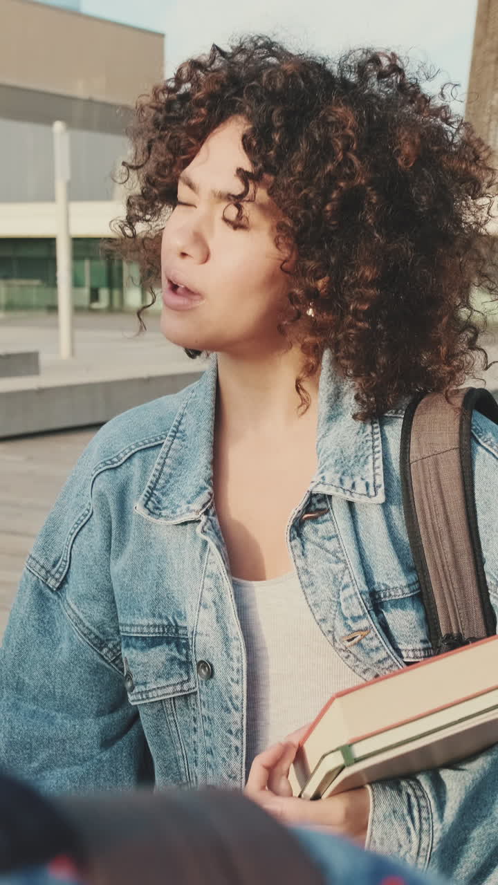 Giovane donna con capelli ricci nel campus