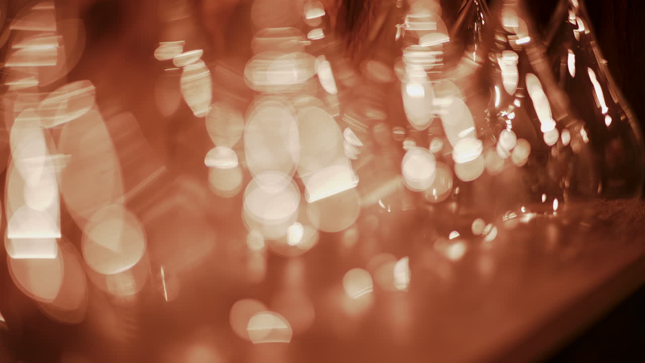 Close up view of multiple glass vessels softly illuminated with warm light that creates a golden bokeh effect in the background