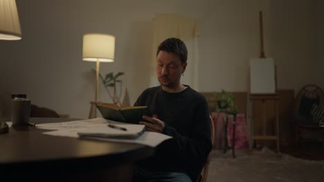 man reading book in home studio