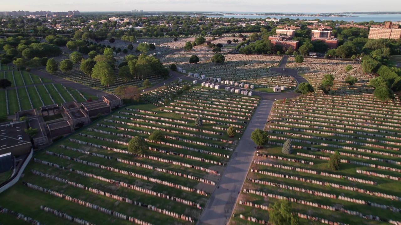Splendida ripresa aerea di lapidi in un vecchio cimitero, erba verde alla luce della sera