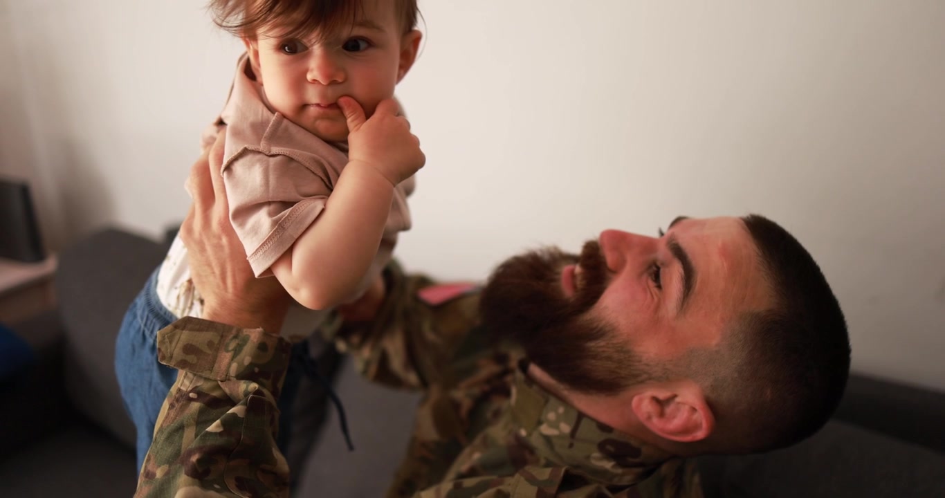 Padre militare felice che gioca con il suo bambino a casa