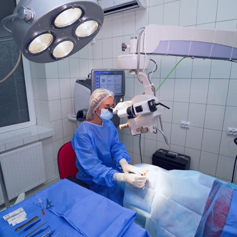 specialist making an operation on eyes with the microscope. female doctor in medical uniform uses microscope during eye surgery in a hospital.