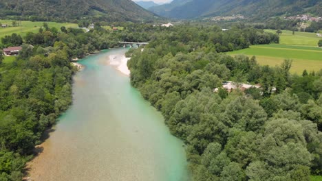 drone flies forward above beautiful clean turquoise soca river in summer, slovenia