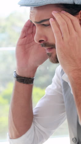 un hombre de negocios hipster frustrado usando su portátil.