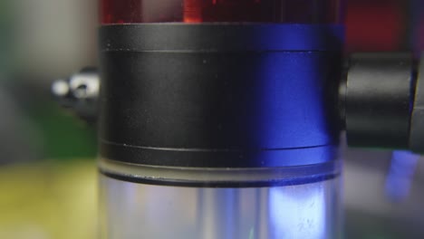 inclinarse hacia abajo para revelar la cámara de un bong de agua para la marihuana llenándose de humo mientras la cámara burbuja mientras alguien toma un golpe