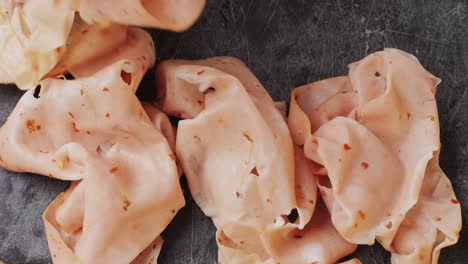 ham italian mordatella, man slices of traditional italian antipasti mortadella sausage on a wooden cutting board, close up macro of chicken or turkey jamon, fat breakfast dish.