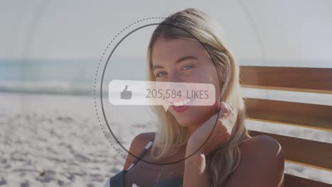 Like-icons-with-increasing-numbers-against-portrait-of-caucasian-woman-smiling-at-the-beach