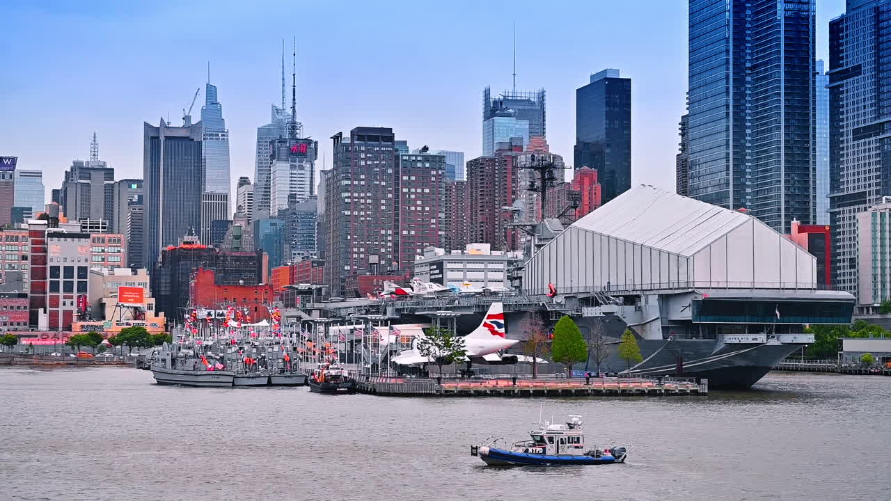 Docks with diverse boats at Hudson River. Numerous tall buildings and skyscrapers of New York at backdrop