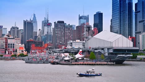docks with diverse boats at hudson river. numerous tall buildings and skyscrapers of new york at backdrop