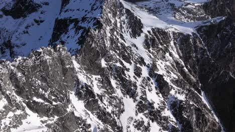 Wild-rugged-rocky-and-snowy-mountains-on-beautiful-day-with-blue-skies-and-rolling-clouds