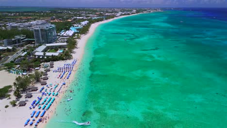 drone pulls back to unveil seven mile beach's white sand and vivid blue caribbean waters in grand cayman