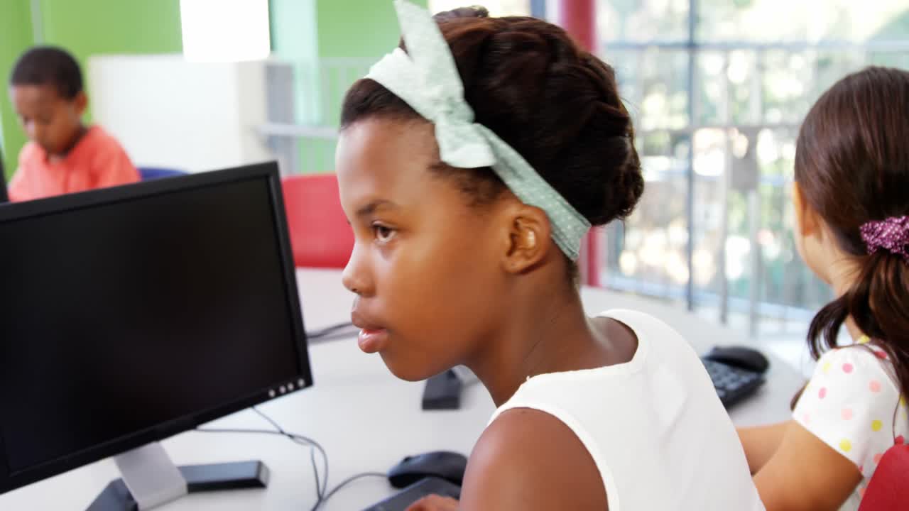 Schoolgirls using computer in classroom