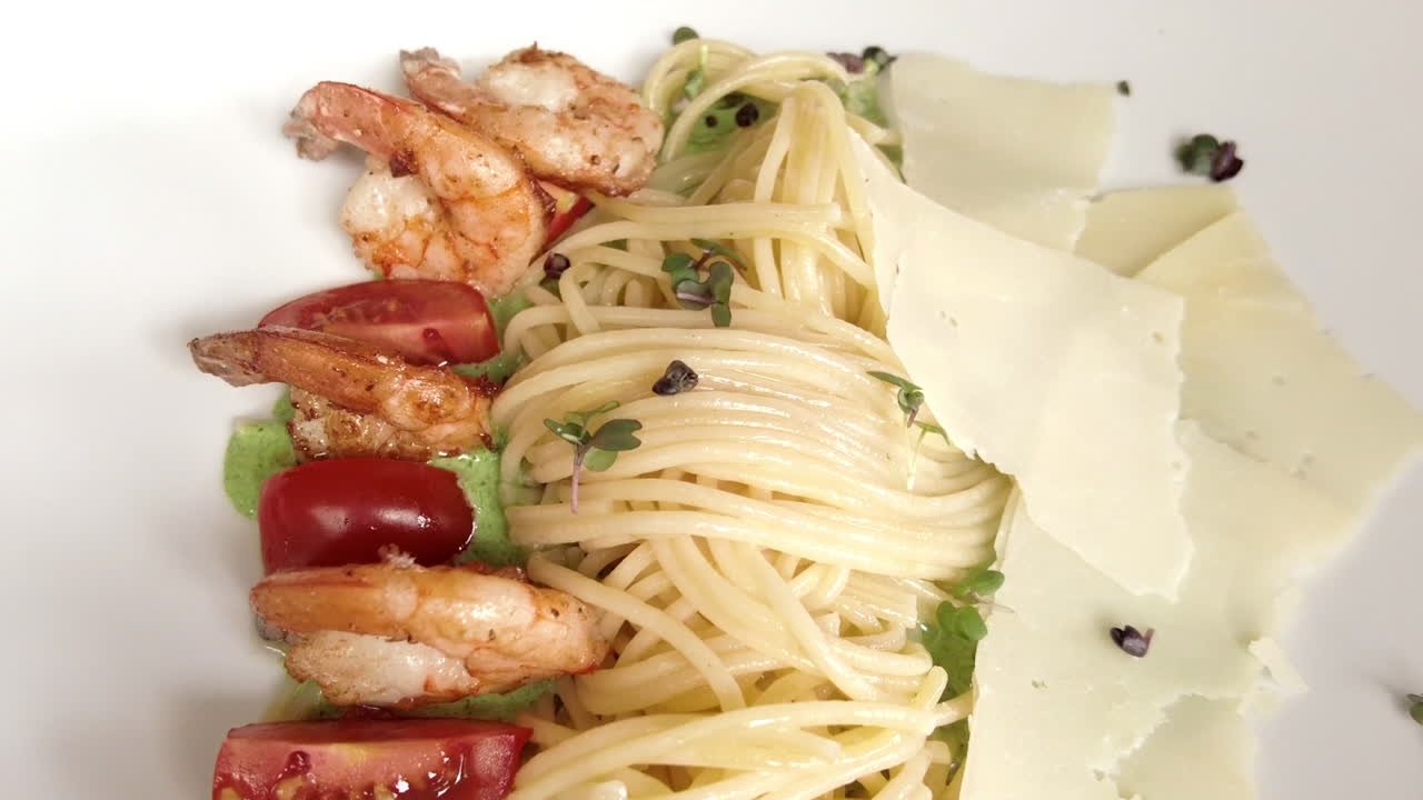 Close up of spaghetti pasta with shrimp, tomatoes and parmesan