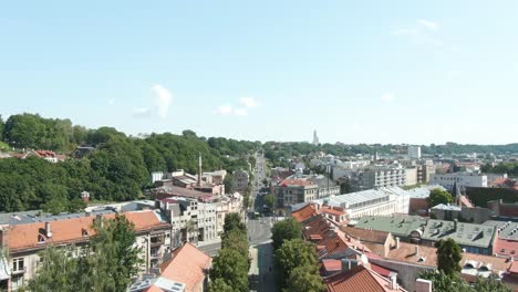 tilting up aerial drone shot of kaunas city old town and savanoriai prospect street while vechiles are moving up the hill