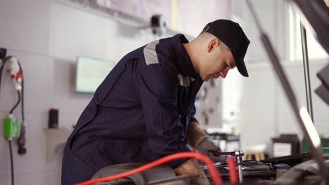 car mechanic using wrench to repair the engine in a car service