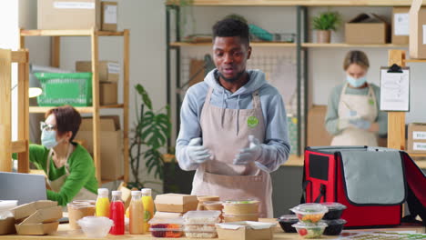 hombre negro alegre que anuncia el servicio de entrega de comida ecológica