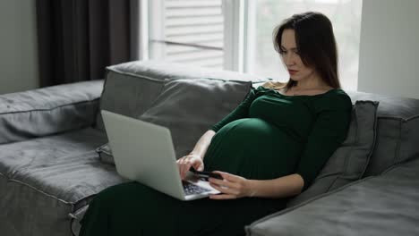 Pregnant-woman-using-credit-card-shopping-online-at-home