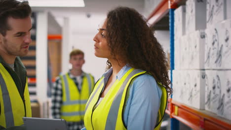 Workers-With-Digital-Tablet-In-Warehouse-Training-Male-Intern-Standing-By-Shelves