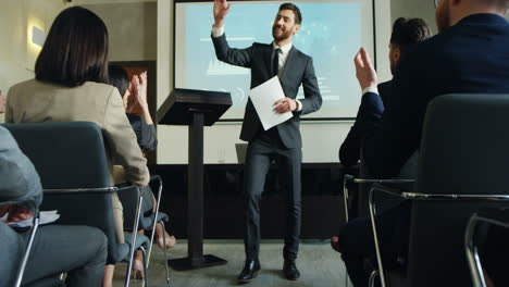 caucasian businessman at the business congress ending his speech and going away while giving five to audience