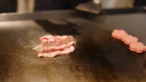 ground pork sizzling as it cooks on griddle.