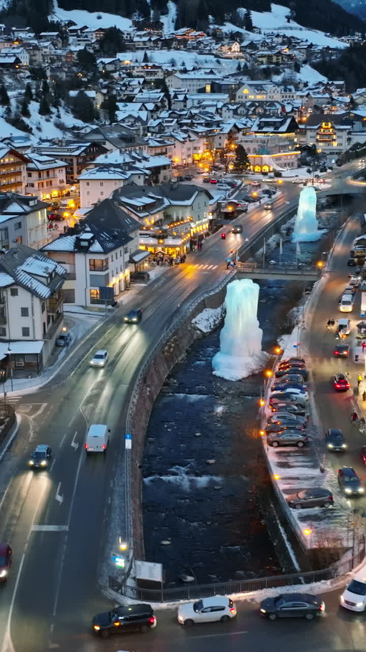 Aerial drone view of the Ortisei town covered in snow at night, within the Dolomites, in northern Italy. Vertical