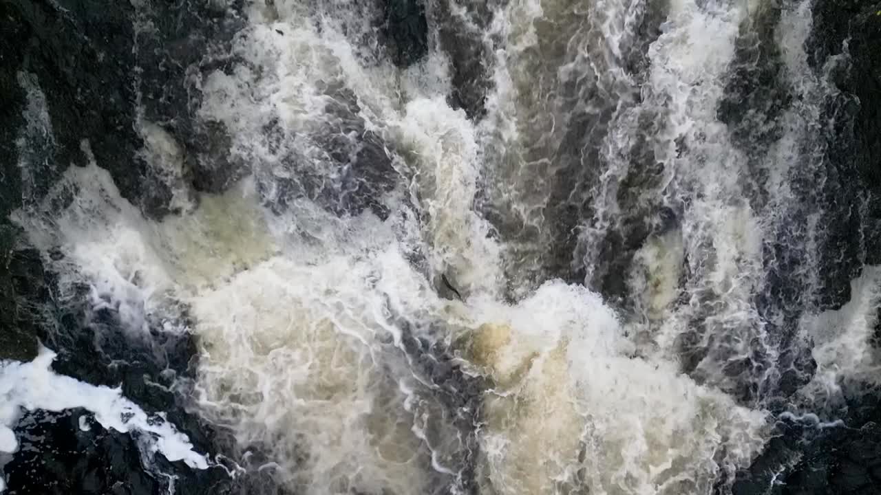 Aerial wide angle view of waterfall showing two Atlantic Salmon(Salmo Salar) leaping during anual migration in Perthshire, Scotland