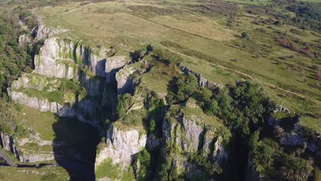 Panning-shot-of-rocky-flat-mountain-wall-with-sparse-trees-and-plateau