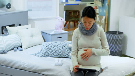 pregnant woman using digital tablet at home 4k